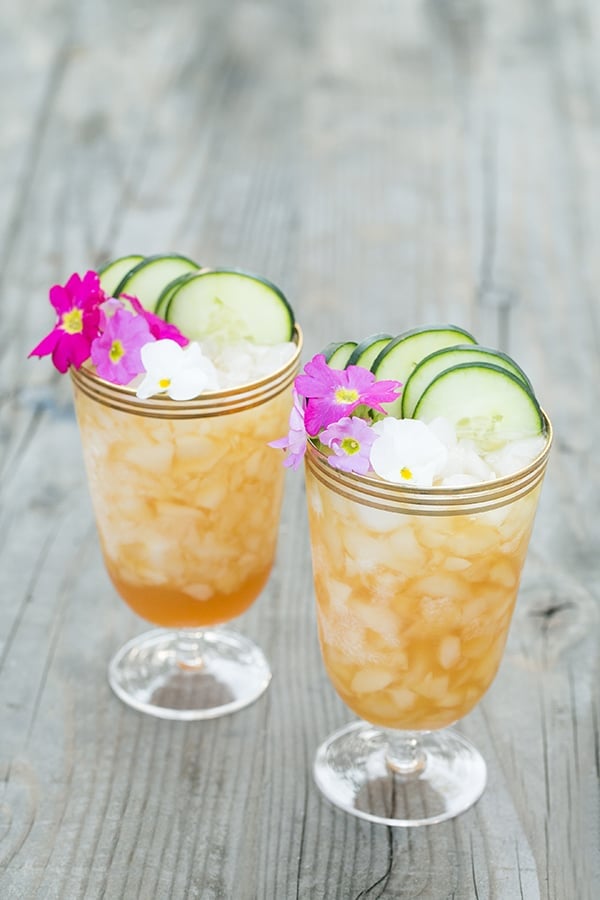 Pimm's Cup recipes garnished with edible flowers and cucumbers.