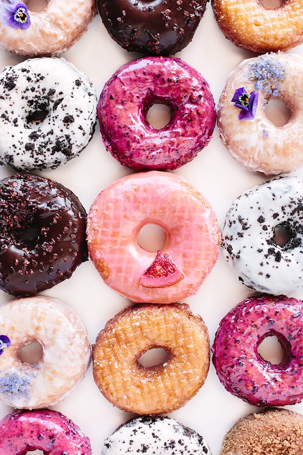Photos of colorful pink, chocolate and glazed doughnuts at Sidecar Doughnuts