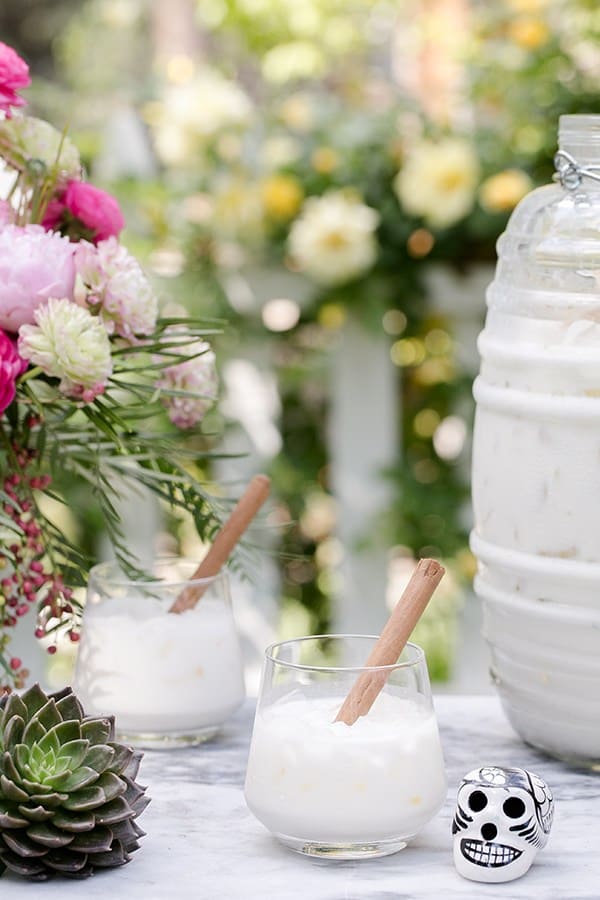 Mexican horchata in a small glass with a cinnamon stick.