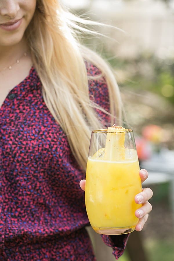 Girl holding a pineapple cocktail