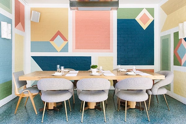 Outdoor eating area with colorful block wall