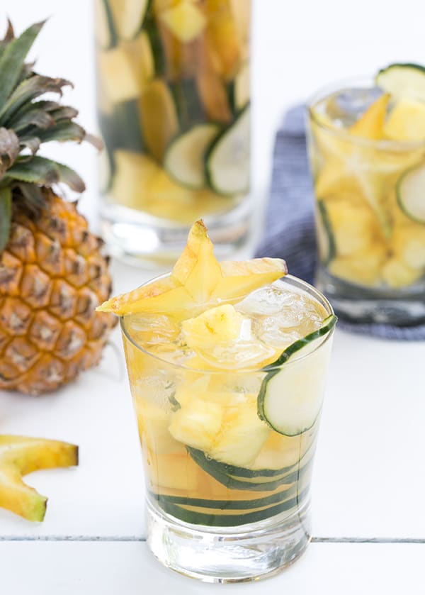 Sake in a glass with cucumber and pineapple slices.