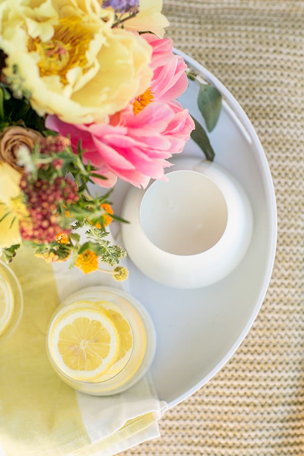 Tray with candle and flowers on a poof.