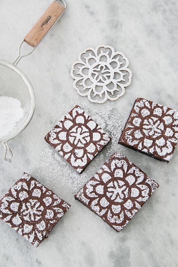 Chocolate brownies with a stencil and powdered sugar design.