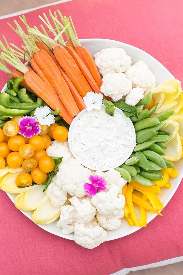 Fresh vegetables and dip on a pink pillow.
