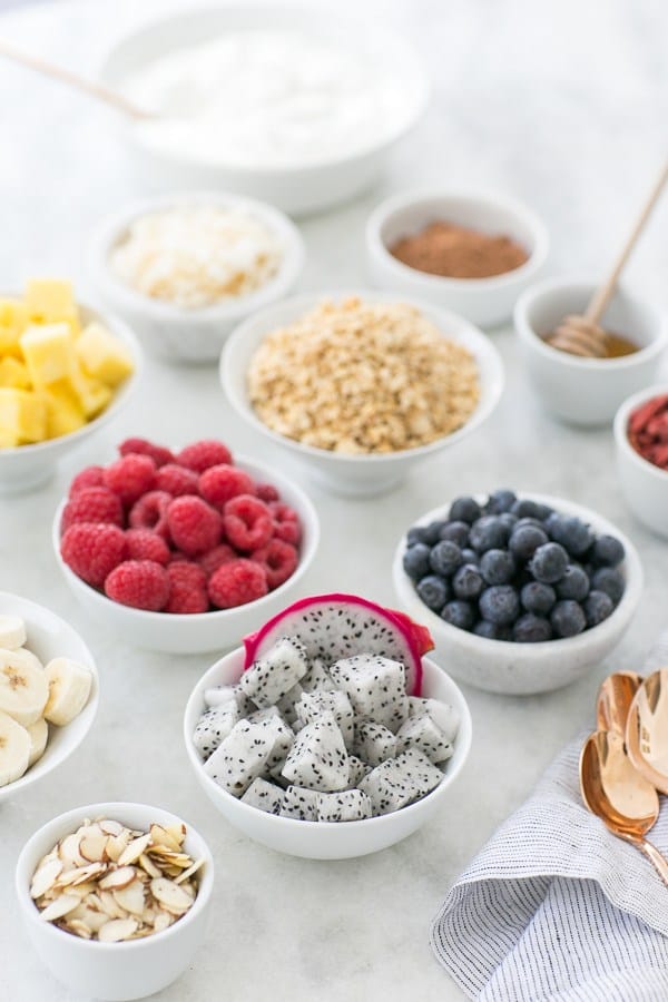 White bowls filled with fruit and berries. 
