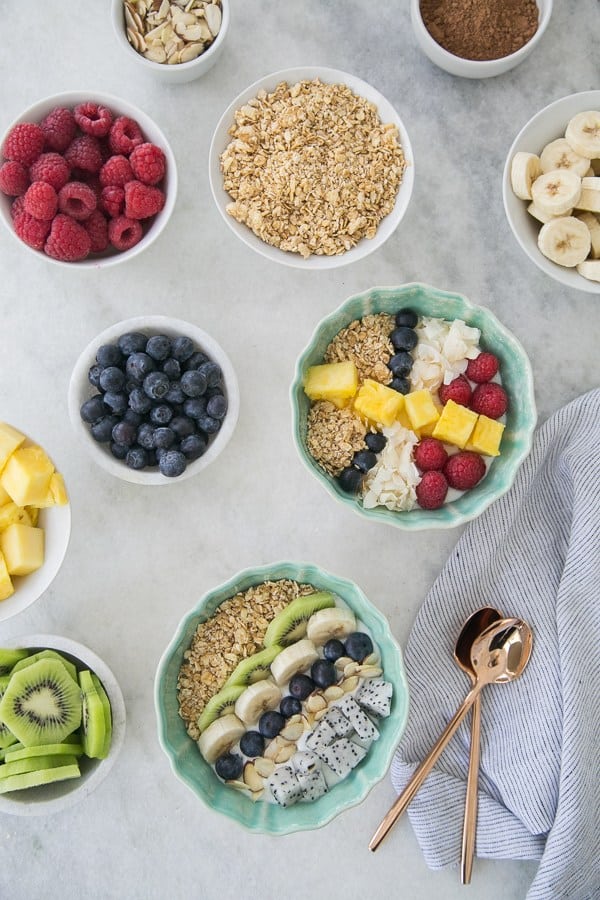 two bowls filled with yogurt and fruit.