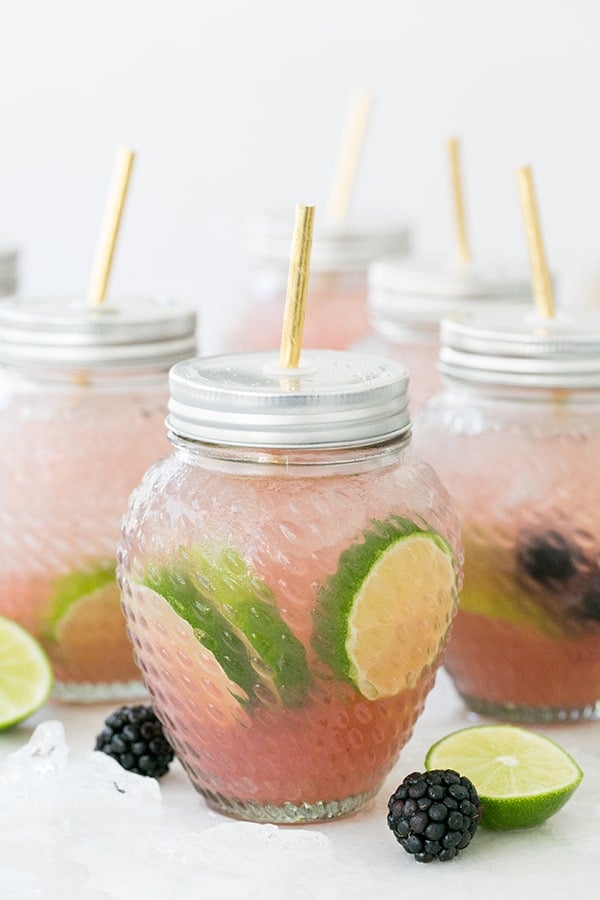 shot of blackberry margarita in a glass jar - lime wedge