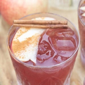 Apple pie sangria with thinly sliced apples and cinnamon sticks.