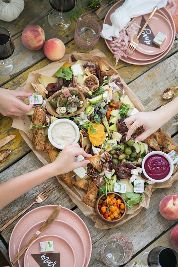 hands reaching for food on the charcuterie platter - charcuterie boards