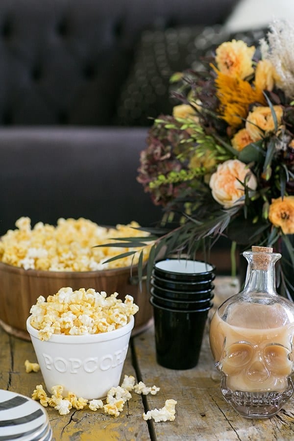 Popcorn in a bowl with skeleton decanter to watch Halloween movies.