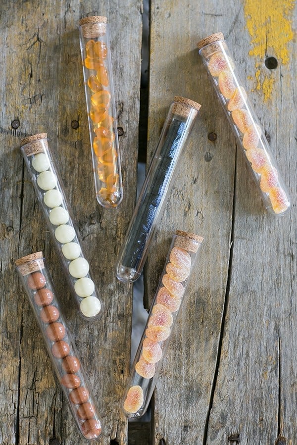 Halloween candy in test tubes on wooden table.
