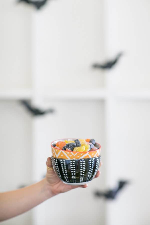 Hand holding halloween candy in small bowls. 