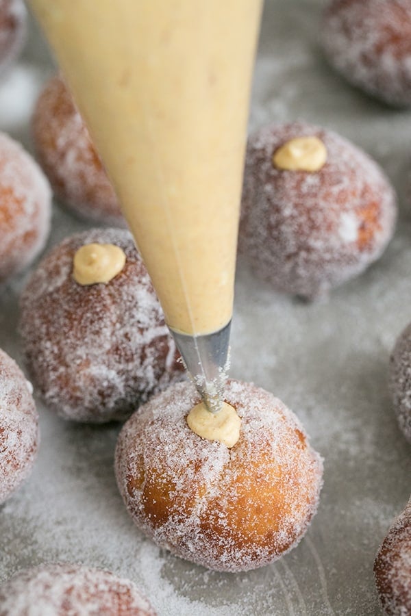 shot of homemade donut holes being filled