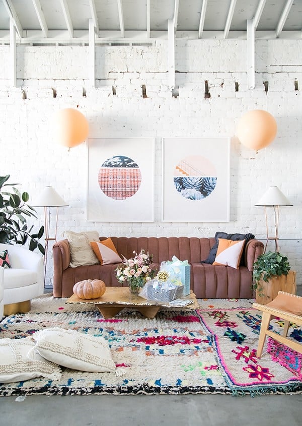 pink couch, balloons and colorful rug for a baby shower 