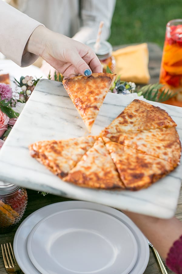 Hand grabbing a slice of pizza 