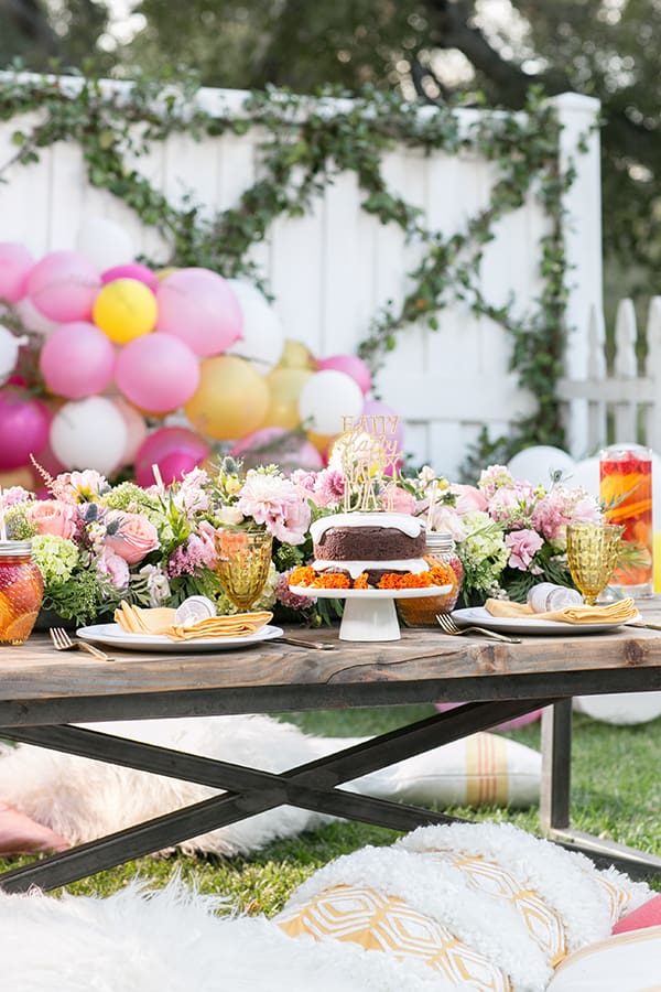 Gluten free birthday party setting with cake, flowers and balloons. 