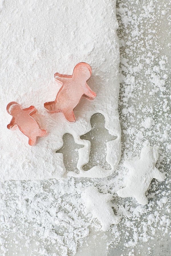 Gingerbread cutouts cutting into a sheet of homemade marshmallows 