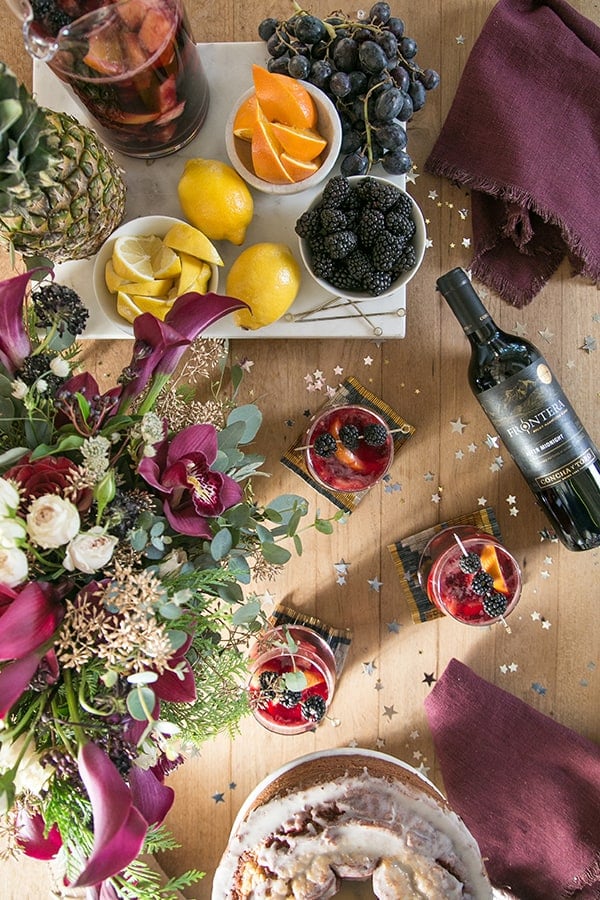 Overhead picture of fruit on a bar, wine bottle and glass of sangria 