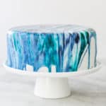 Blue tie-dye frosting dripping from the side of cake