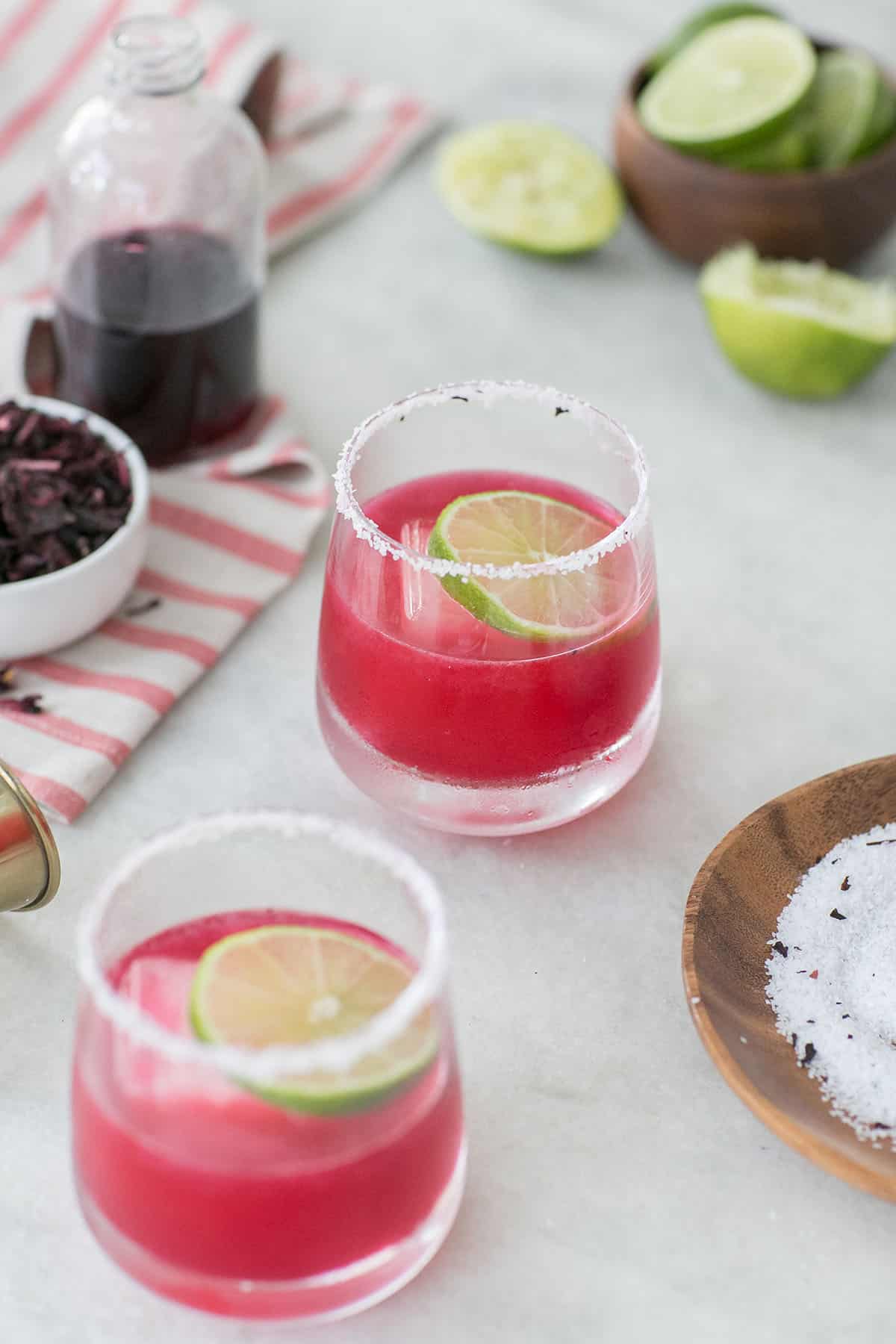 Pink cocktail with lime and a slated rim.