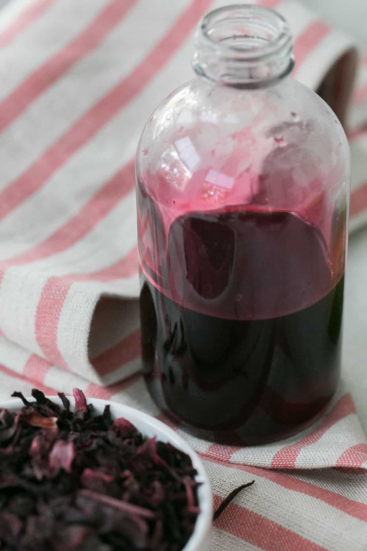 Hibiscus simple syrup in a glass bottle. 