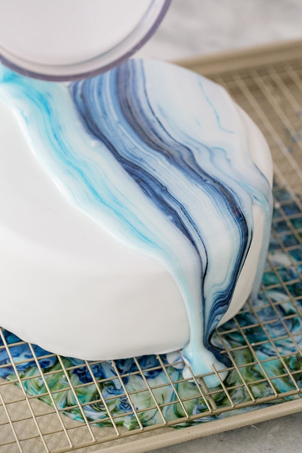 marble icing being poured over the cake