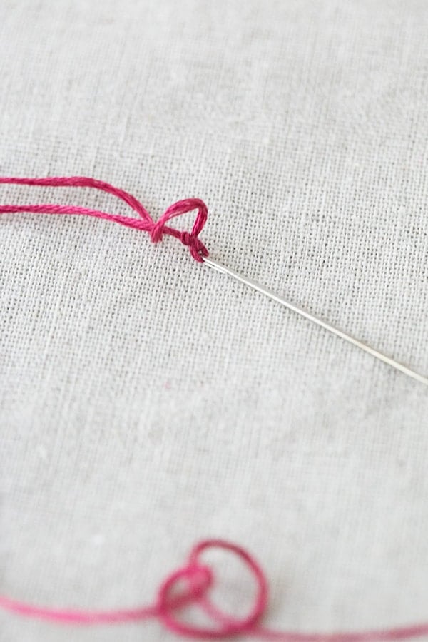 Embroidery pin and pink thread.