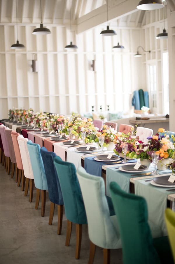 Colorful chairs and a table with flowers.