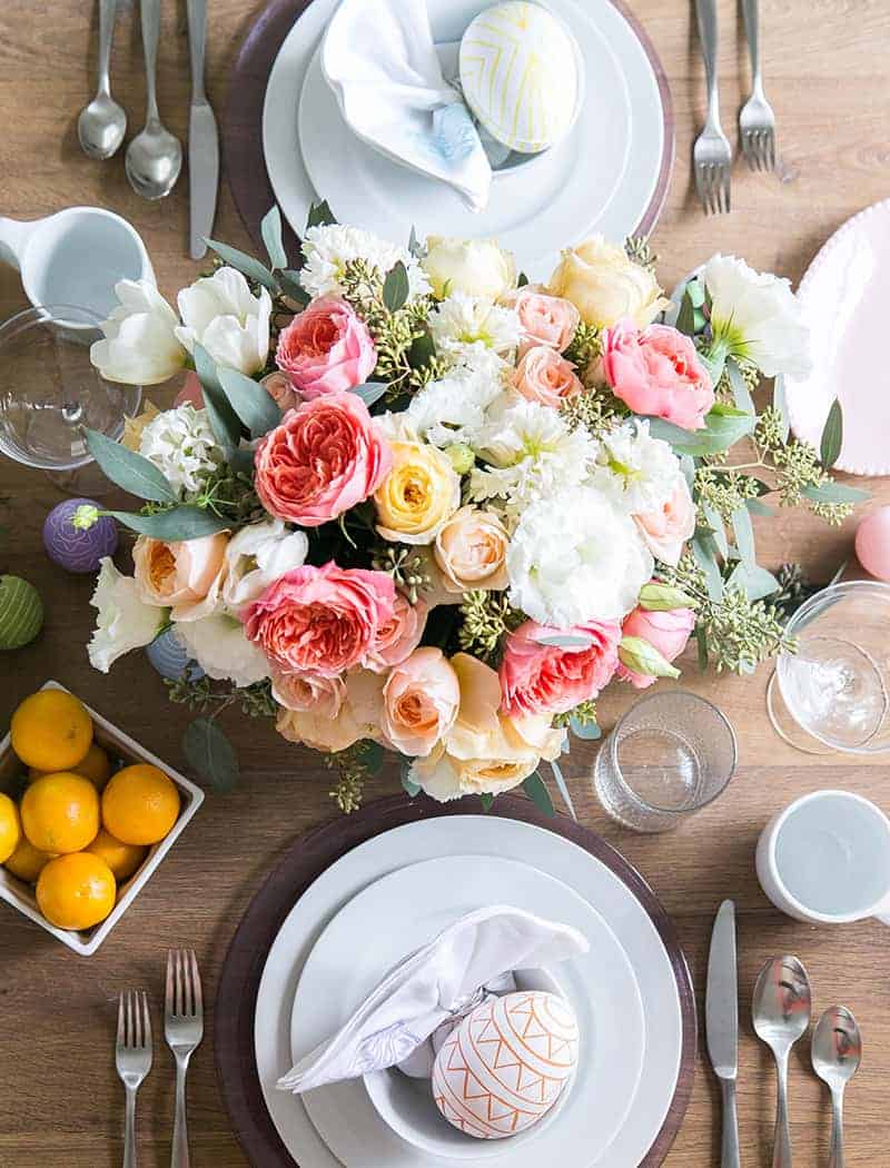 Easter table setting with flowers, dinnerware and Easter eggs 