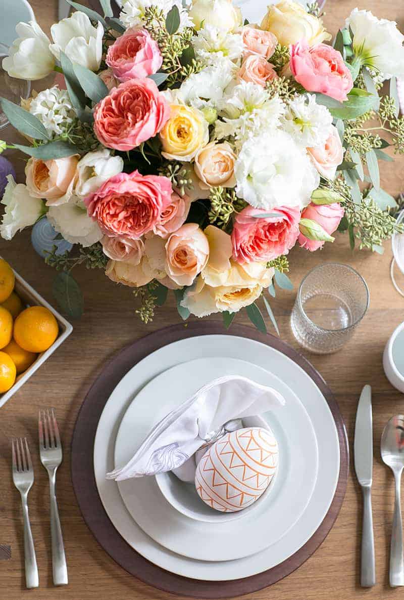 Easter surprise eggs on white plates with flowers.