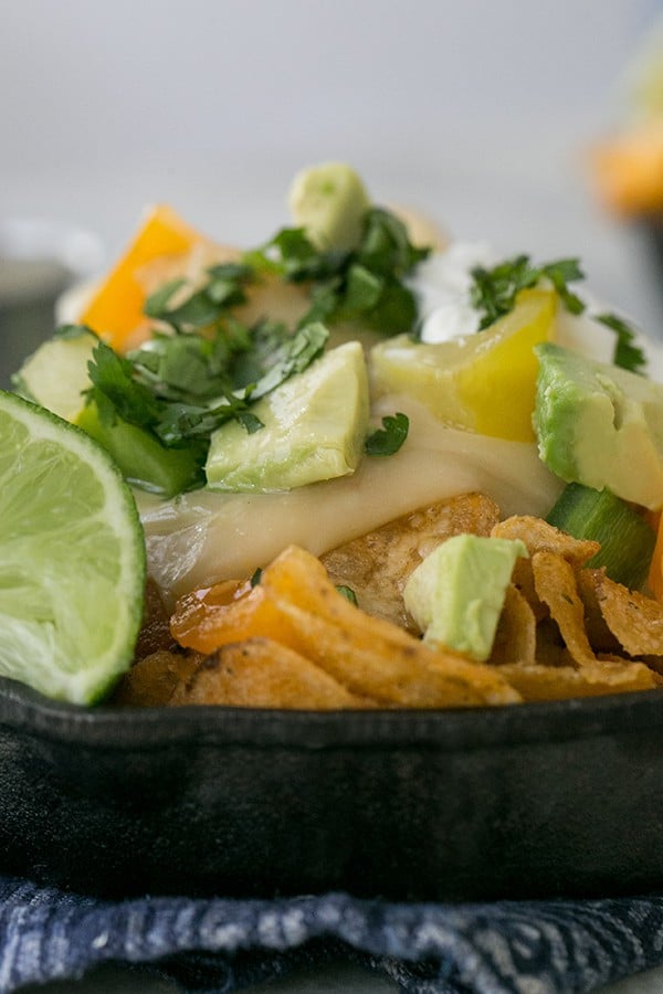 Kettle chips layered with beer cheese and avocado, lime and cilantro 