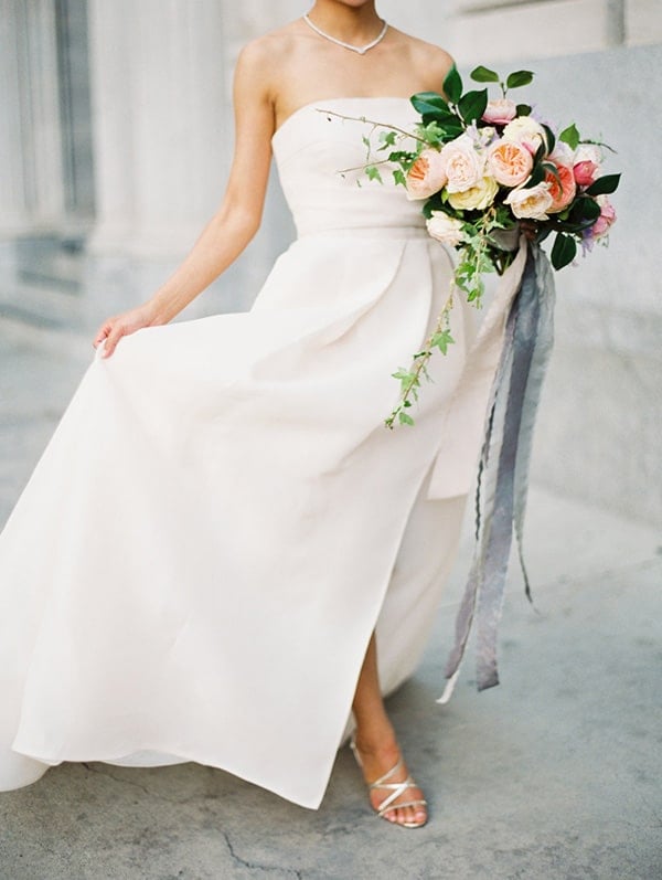 Bride in a white dress with bouquet of flowers.