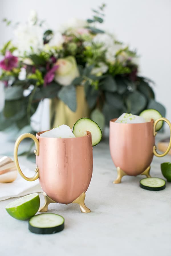 Cocktail in a copper mug with cucumber and lime. 