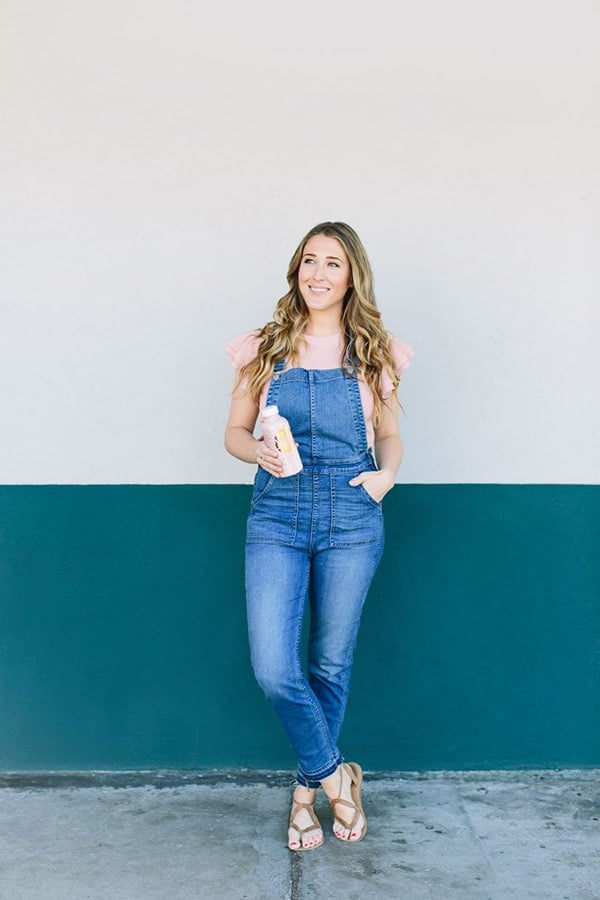 Eden Passante against a wall, holding moon juice 