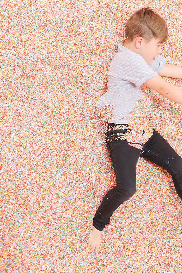 Little boy in a pool of sprinkles.