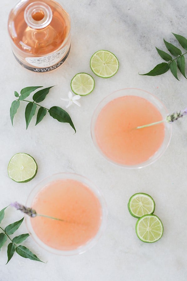 Floral cocktail using Pomp & Whimsy with lime wedges and flowers.