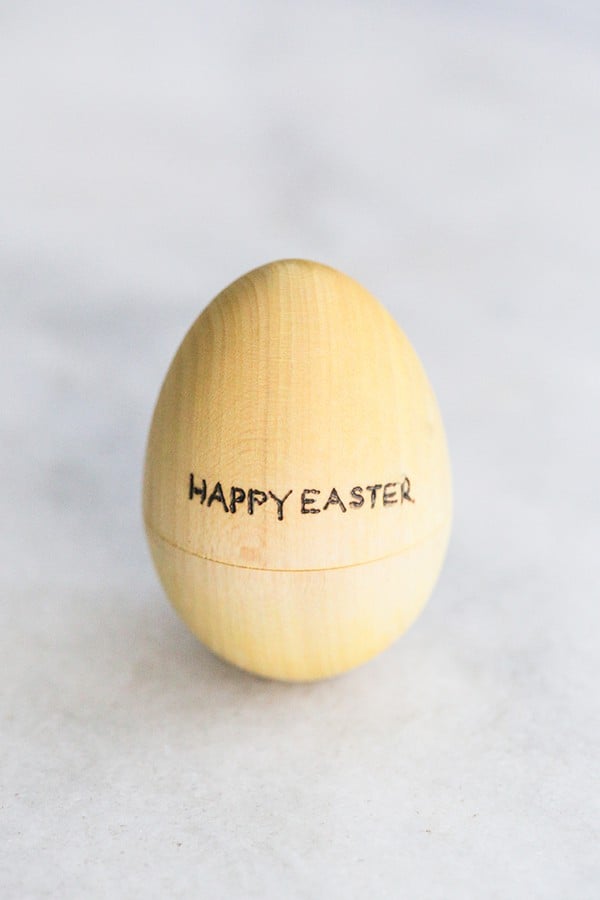 Yellow wooden egg that says happy Easter