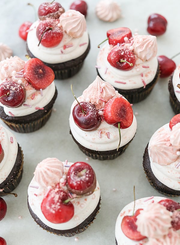 Chocolate cherry cupcakes with cherries, buttercream and sprinkles.
