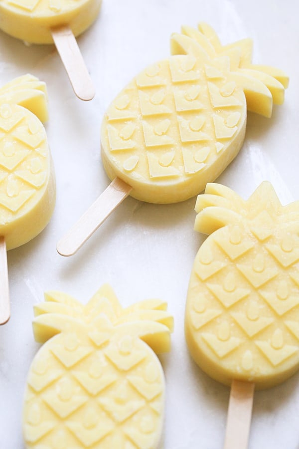 pineapple coconut rum  popsicles on a marble table.