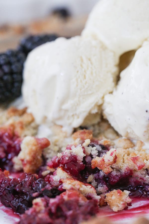 Cerca de la tarta de moras con helado de vainilla.