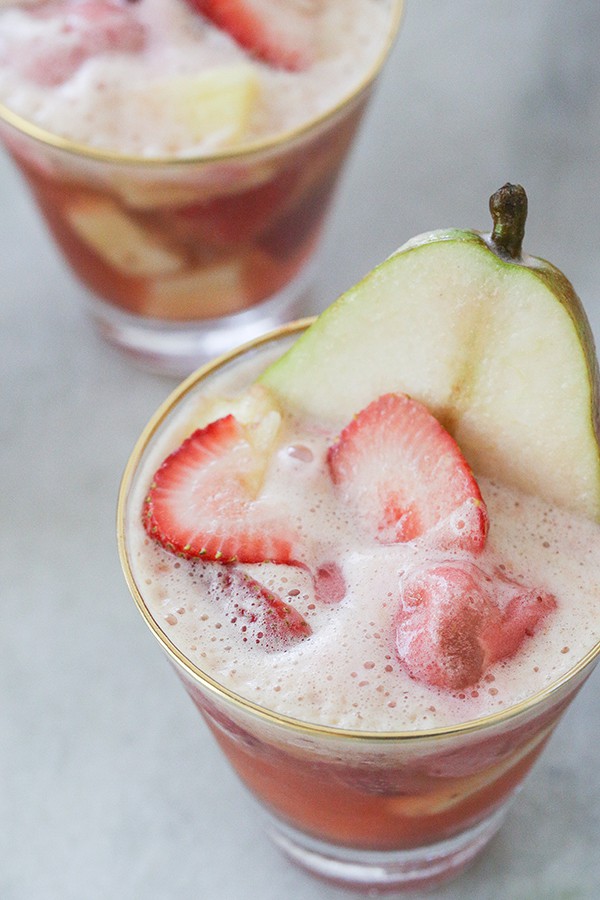 Bubbly cocktail with sliced strawberries, pears, sherbet and Cava.