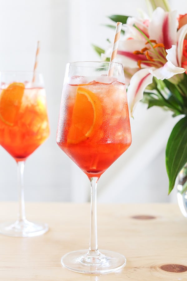 Aperol spritz with an orange slice and stripe straws.