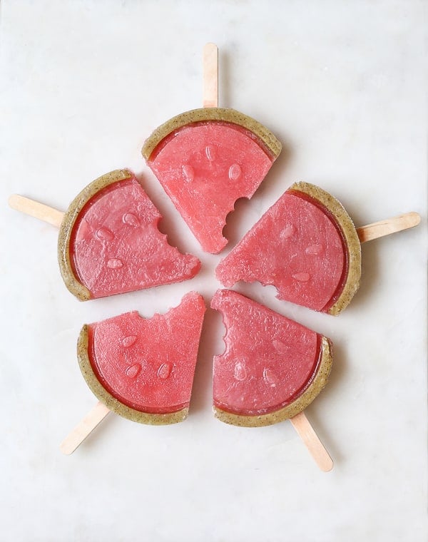 Watermelon popsicle recipe with tequila on a marble table.