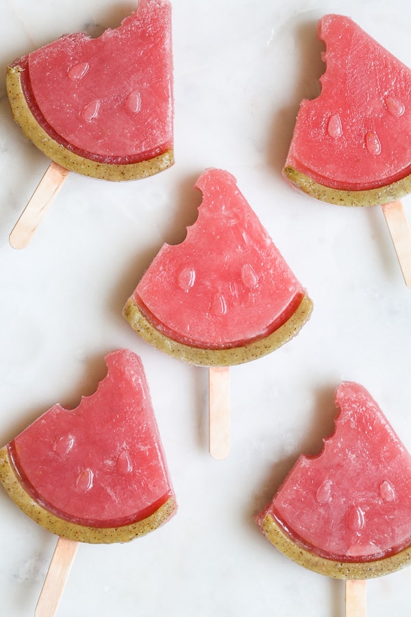 Watermelon popsicles on a marble table.