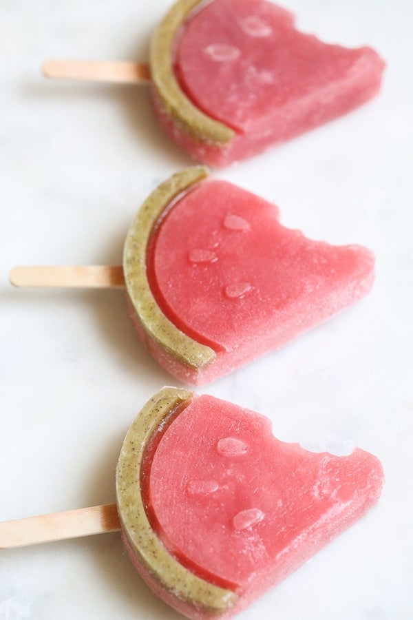 Three watermelon popsicles in the shape of watermelons. 