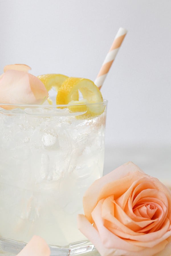 Rosevandscocktail med en rose og et ferskenstrå