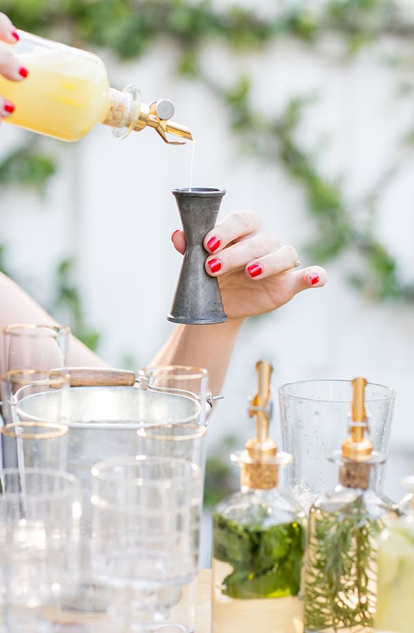 Pouring citrus juice into a cocktail jigger 