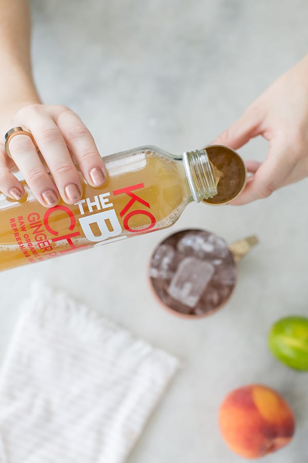 Pouring Kombucha into a shot glass.