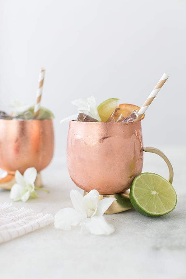 Moscow  Mules in modern copper mugs with a straw and limes.